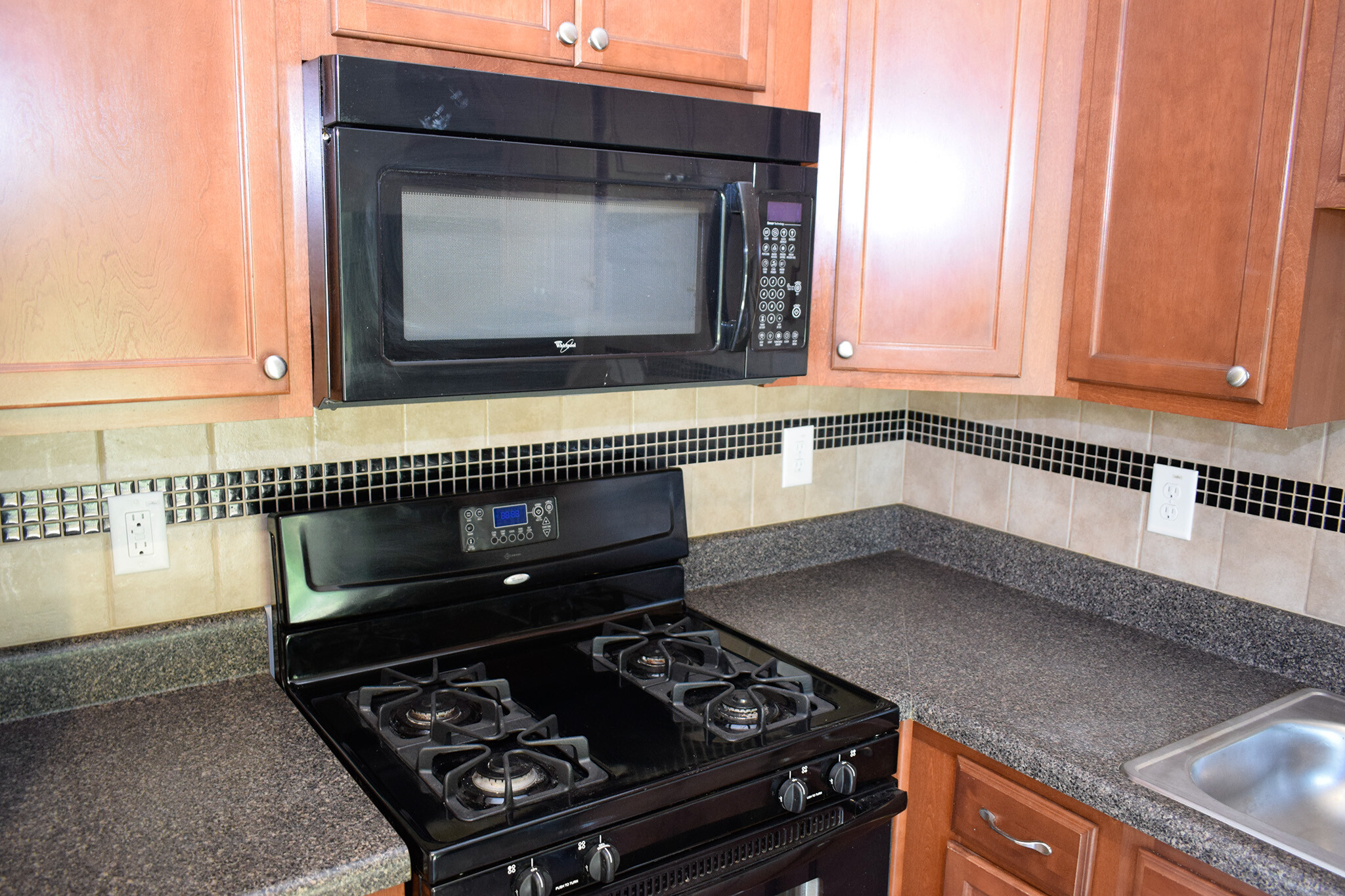 Matching black gas cooktop/oven and built-in microwave convey with the property