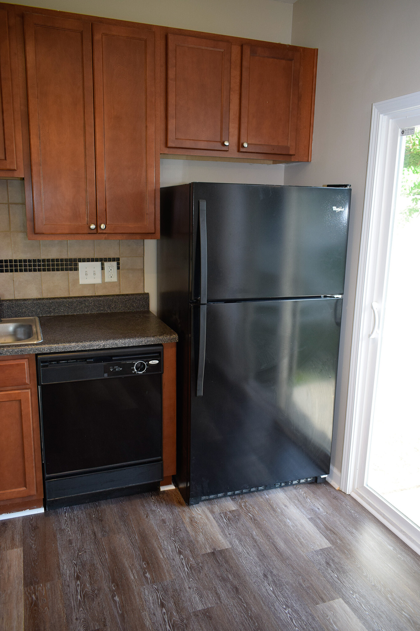 Matching black refrigerator and dishwasher convey with the property